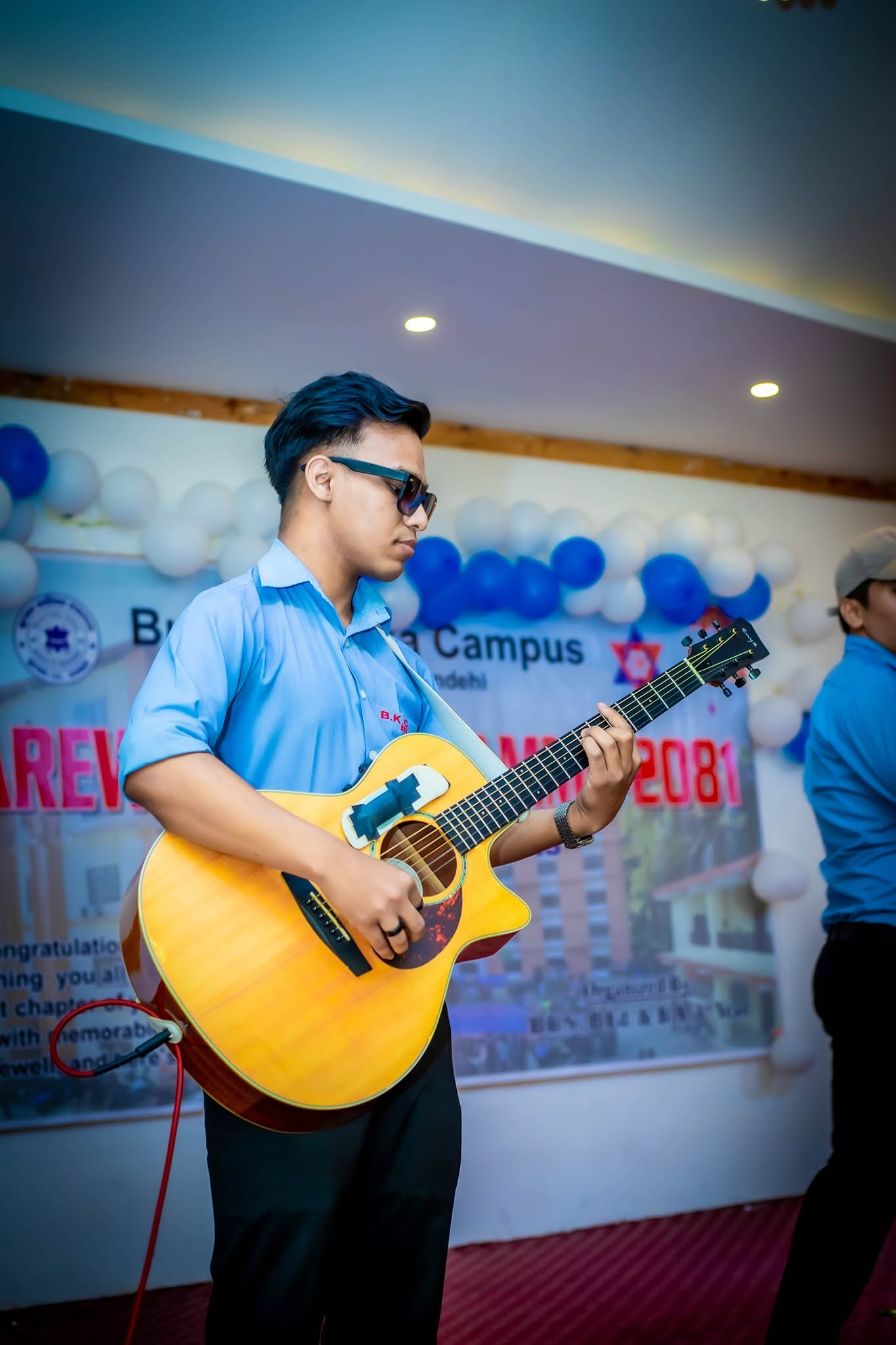 Pratik playing an acoustic guitar at a live event