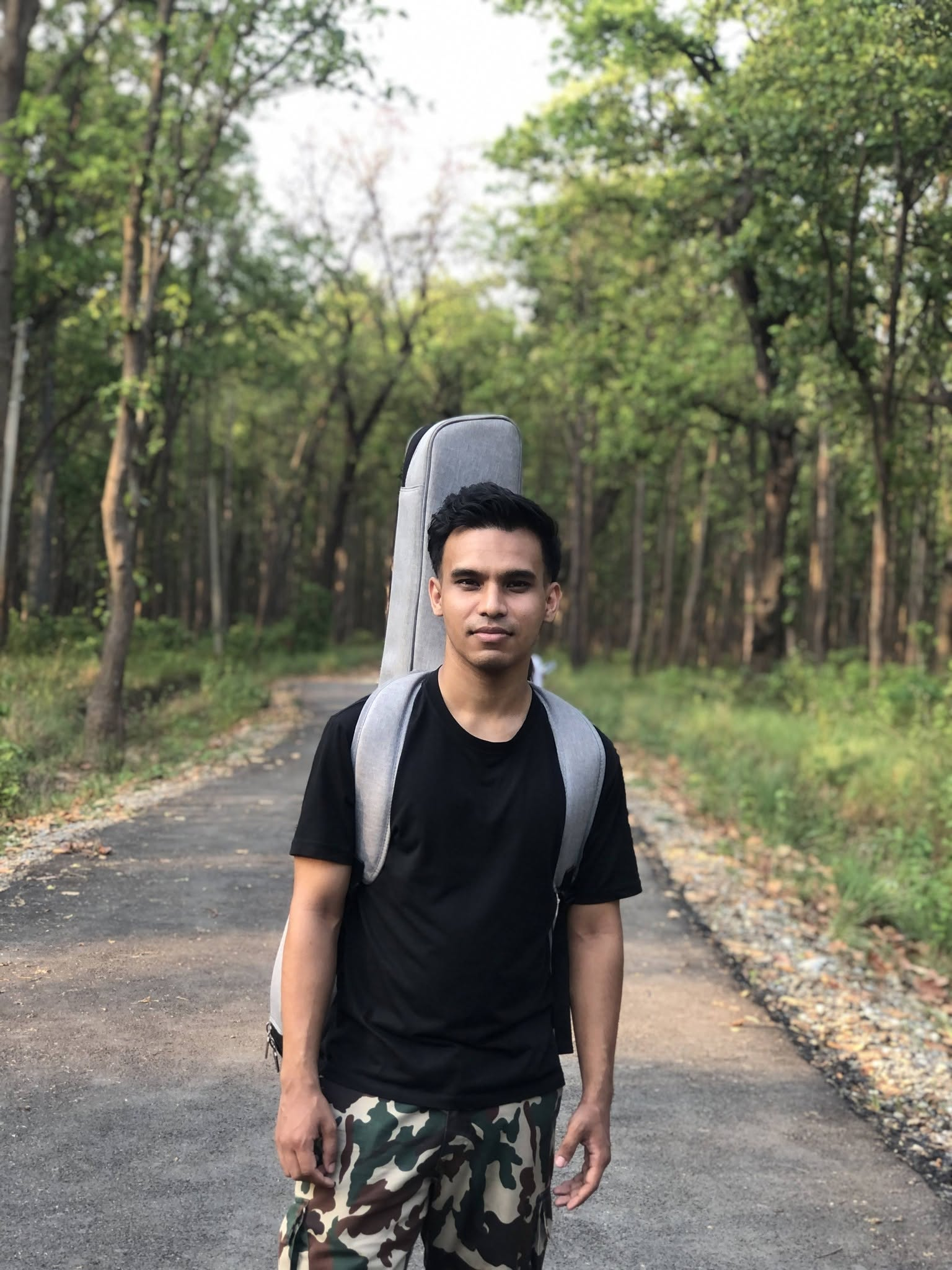 Pratik Thada with his guitar case outdoors